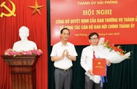 Phó Bí thư Thường trực Thành ủy Hải Phòng trao Quyết định và tặng hoa cho ông Trần Thanh Minh.