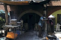 Một người đàn ông điều hành một cơ sở kinh doanh thực phẩm tại nhà ở Colombo, sử dụng bếp gỗ truyền thống của Sri Lanka khi mất điện ngày 7/3/2022 sau khi hai công ty gas chính ngừng cung cấp do Sri Lanka đang vật lộn với tình trạng thiếu ngoại tệ trầm trọng.