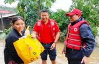 Người dân rốn lũ vui mừng khi nhận được quà cứu trợ.