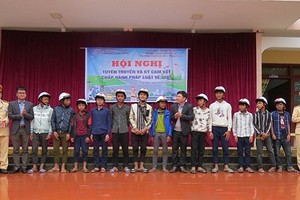 Đại diện báo PLVN khu vực Bình Trị Thiên và Phòng CGST Quảng Bình tặng mũ bảo hiểm cho học sinh vùng biên huyện Minh Hóa.