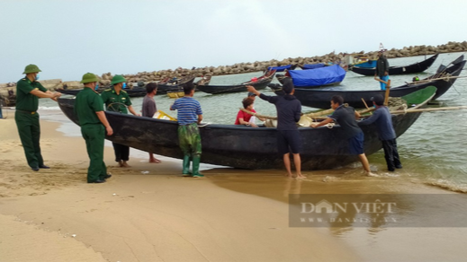 Bộ đội Biên phòng giúp ngư dân Hà Tĩnh đưa thuyền lên bờ tránh bão số 8. Ảnh - Dân Việt.
