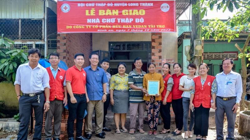 Bà Nguyễn Thu Thủy (thứ 6 từ trái sang) – đại diện Vedan Việt Nam trao nhà cho gia đình bà Huỳnh Thị Hồng tại xã Bình An.