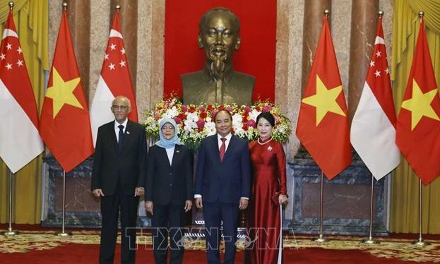 Chủ tịch nước Nguyễn Xuân Phúc và Phu nhân cùng Tổng thống Singapore Halimah Yacob và Phu quân tại lễ đón. Ảnh: Thống Nhất/TTXVN