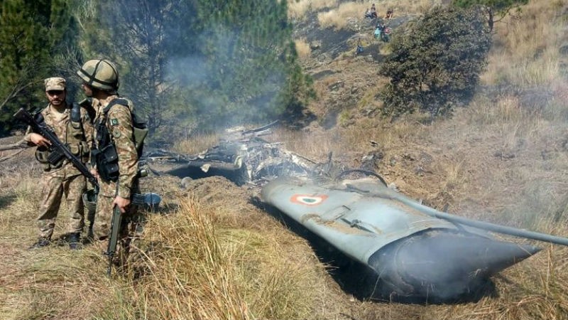Binh lính Pakistan bên cạnh xác máy bay Ấn Độ bị nước này bắn hạ.