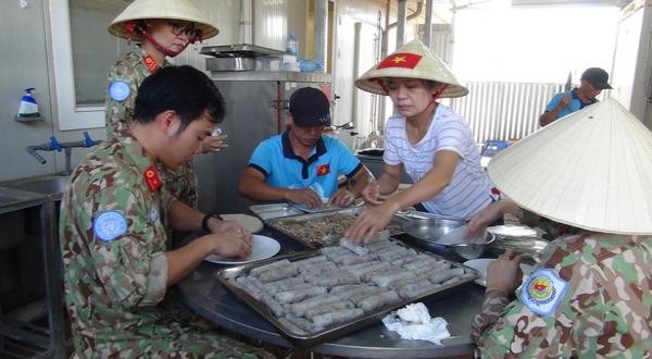 Cán bộ, y bác sĩ VN giúp tổ hậu cần chuẩn bị món Việt tiếp khách (Ảnh: Tuổi trẻ).