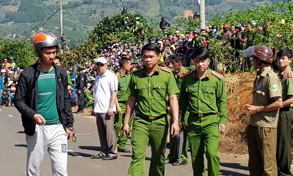 Nghi phạm Lê Sỹ Quốc Thái Anh (đội nón bảo hiểm, bên trái) được đưa đến hiện trường vụ án mạng. Ảnh Lâm Viên/Báo Thanh niên