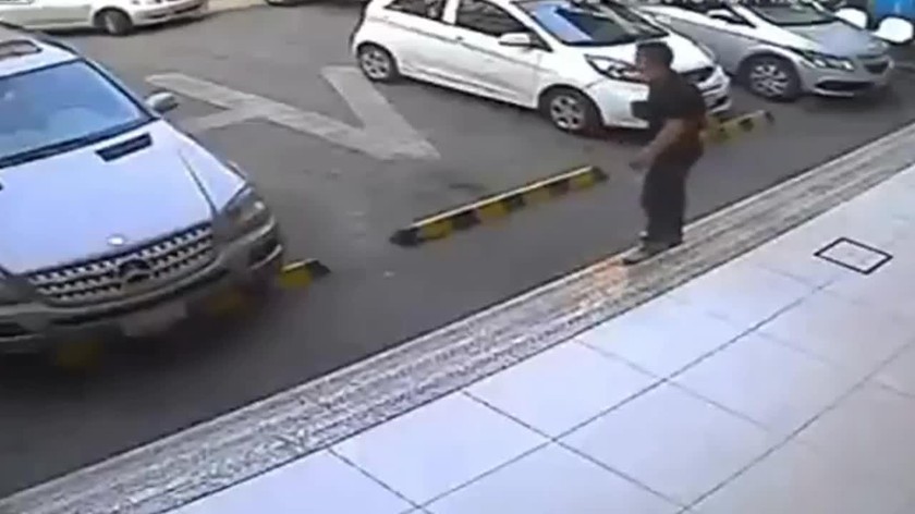 Hình ảnh ghi lại được cho thấy, một người đàn ông đang đứng ra hiệu cho một chiếc sedan màu bạc tiến vào bãi đỗ xe.