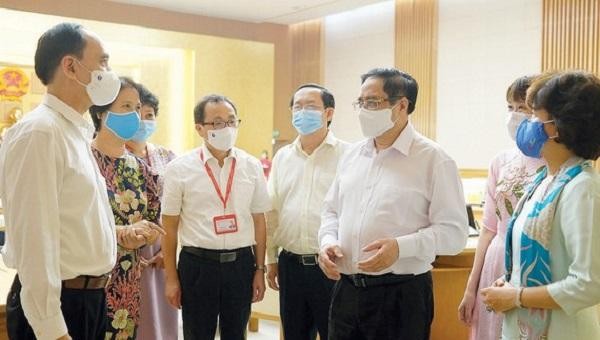 Thủ tướng Phạm Minh Chính trao đổi với các nhà khoa học, các dơn vị DN tham gia sản xuất vaccine phòng COVID-19 tại Việt Nam. Ảnh: Việt Cường