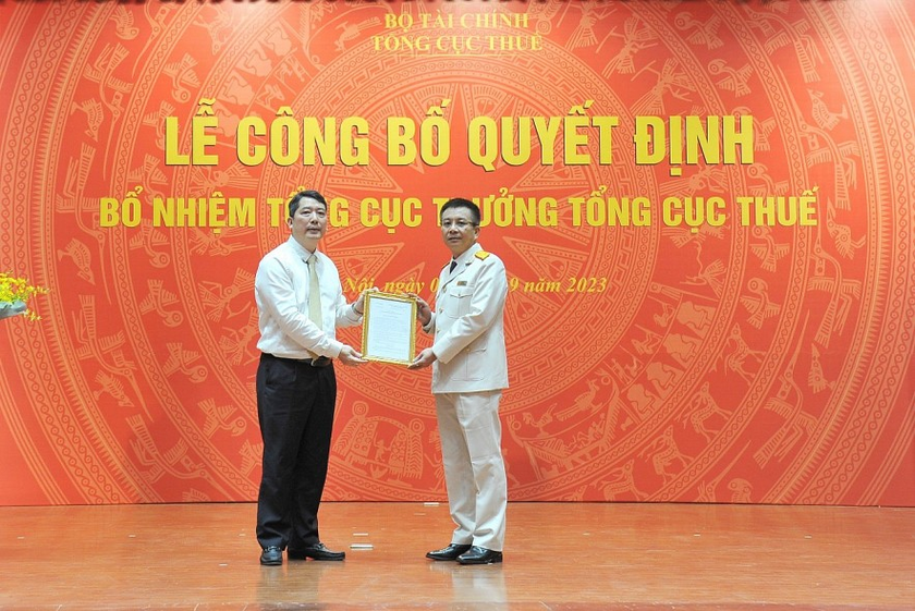 Thứ trưởng Bộ Tài chính Cao Anh Tuấn trao quyết định cho ông Mai Xuân Thành (bên phải). Ảnh: TN
