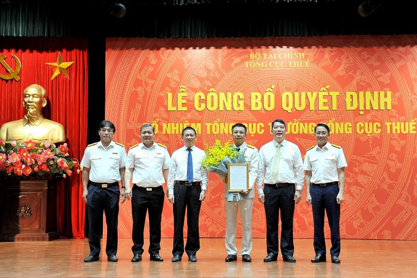 Bộ trưởng Bộ Tài chính Hồ Đức Phớc (thứ 3 từ trái sang) tặng hoa chúc mừng tân Tổng cục trưởng Tổng cục Thuế Mai Xuân Thành. Ảnh: TN