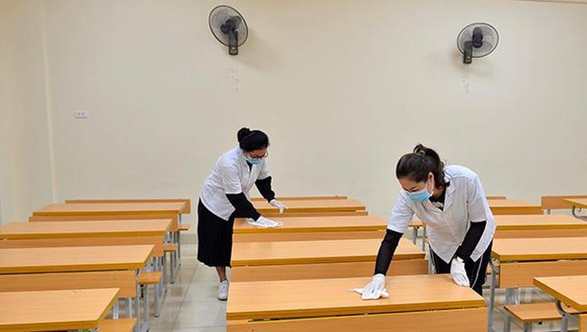 Nhân viên y tế cùng giáo viên trường Tiểu học Hoàng Diệu, Hà Nội tiến hành vệ sinh lau bàn ghế đồ dùng học tập. Ảnh: Lê Phú/TTXVN