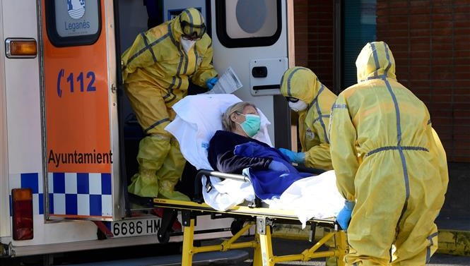 Nhân viên y tế chuyển bệnh nhân nhiễm COVID-19 từ xe cứu thương vào một bệnh viện ở Leganes, Tây Ban Nha ngày 26/3/2020. Ảnh: AFP/TTXVN