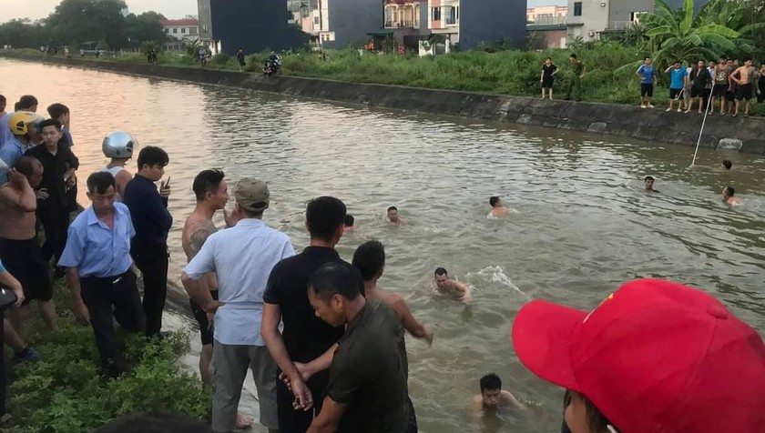Người dân tìm kiếm 3 ông cháu tại tuyến kênh chảy qua thị trấn Hợp Hòa chiều 15/9.