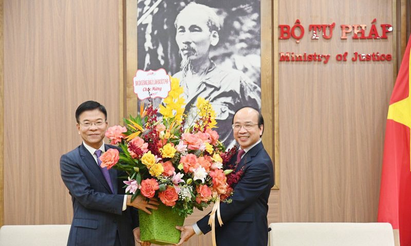 Bộ trưởng Bộ Tư pháp Lê Thành Long tặng hoa, chúc mừng tân Chủ tịch Viện Hàn lâm Khoa học Xã hội Việt Nam Phan Chí Hiếu.