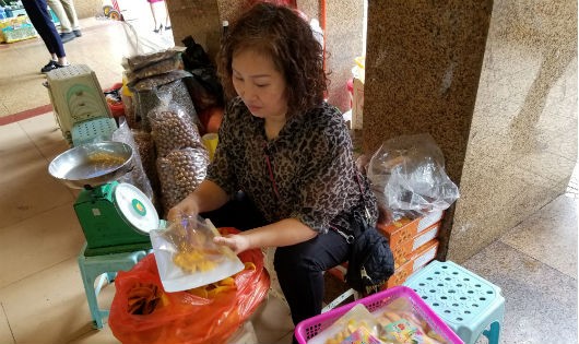 Tiểu thương tự tay đóng gói mứt tại chợ Đồng Xuân