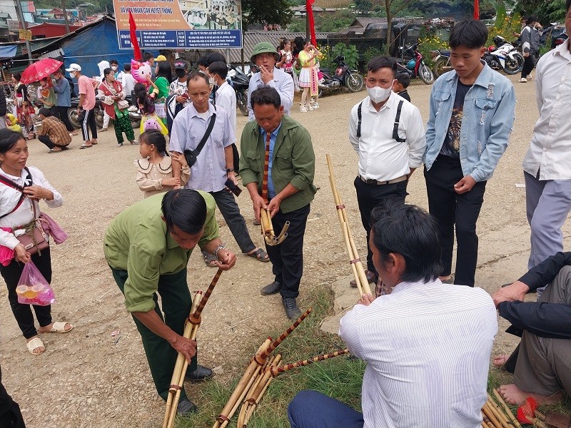 Bà con người Mông xuống chợ xem thổi khèn.