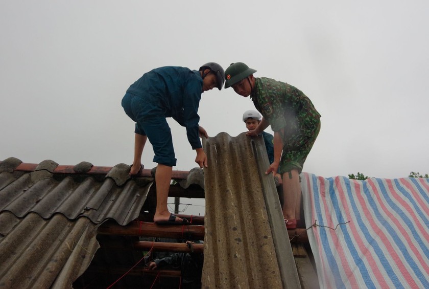 Lực lượng vũ trang giúp các gia đình bị tốc mái lợp lại mái nhà.