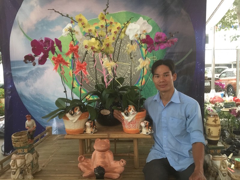 Anh Quang bên bức phông chủ đạo trong gian hàng