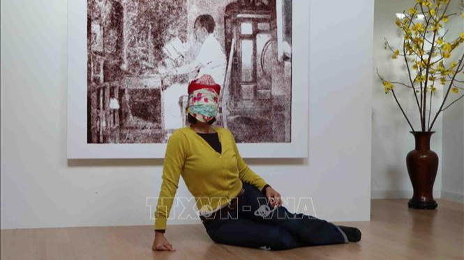 Nghệ sĩ Emmanuel Vincent giới thiệu tác phẩm "Mutante" (Biến thể) lấy cảm hứng từ hình ảnh người phụ nữ Việt Nam khi chạy xe máy trên đường, họ mặc kín từ đầu tới chân như những “Ninja”. (Ảnh: TTXVN)