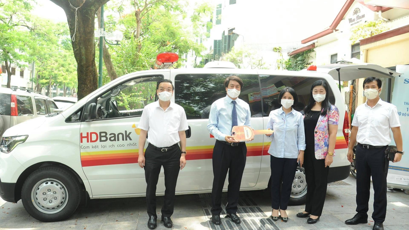 Chủ tịch UBND TP Chu Ngọc Anh (ngoài cùng bên trái) cùng đại diện UB MTTQ Việt Nam TP Hà Nội nhận tượng trưng xe cứu thương do Công ty CP Tập đoàn Sovico ủng hộ.