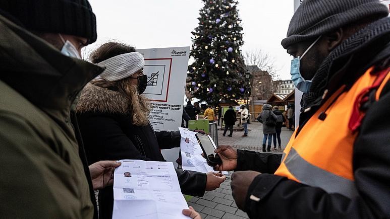 Nhân viên an ninh kiểm tra thẻ sức khỏe COVID-19 để vào chợ Giáng sinh ở Strasbourg, miền đông nước Pháp, ngày 3/12/2021. Ảnh: AP