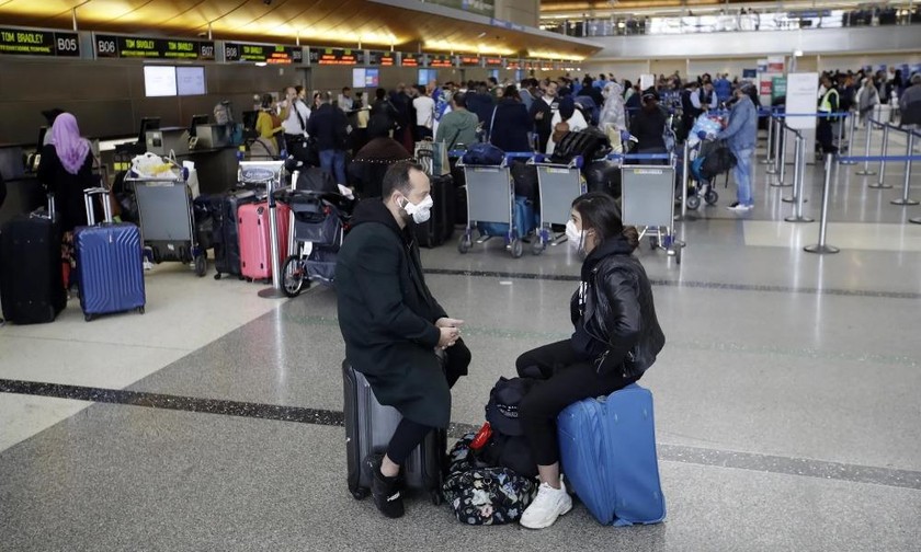 Hành khách đeo khẩu trang chờ đợi làm thủ tục tại sân bay quốc tế Los Angeles (Mỹ) vào thứ Bảy – 14/3. Ảnh: AP.