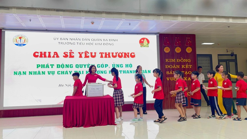 Sau phút mặc niệm, học sinh Trường Tiểu học Kim Đồng góp phần chia sẻ với gia đình nạn nhân vụ cháy chung cư mini tại phố Khương Hạ.