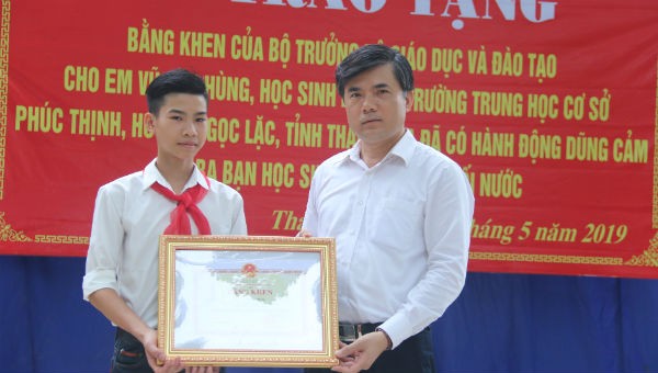 Phó vụ trưởng phụ trách Vụ Giáo dục Chính trị và Công tác học sinh, sinh viên, Bộ GD&ĐT Bùi Văn Linh trao bằng khen của Bộ trưởng Bộ GD&ĐT cho em Vũ Văn Hùng.