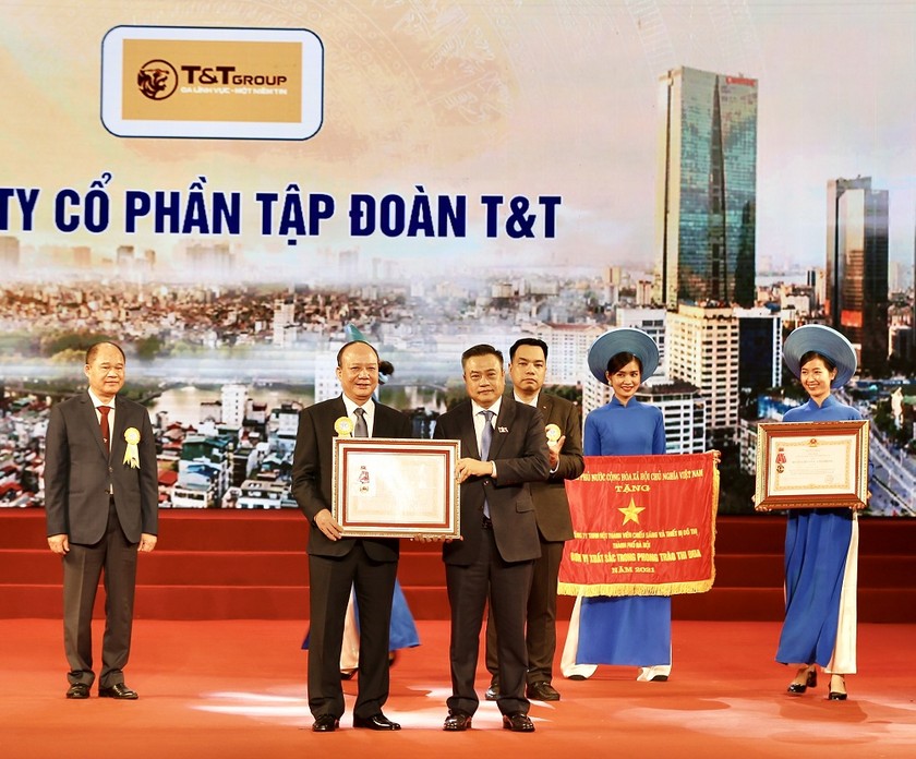 Thừa uỷ quyền của Chủ tịch nước, ông Trần Sỹ Thanh - Chủ tịch UBND TP Hà Nội (bên phải) trao Huân chương Lao động hạng Ba cho đại diện Tập đoàn T&T Group