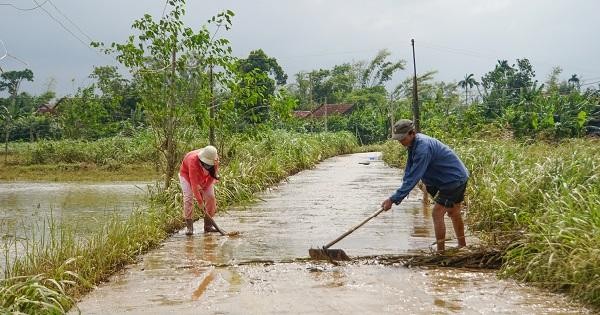 Một số người dân thôn Tân Phước Đông, xã Bình Minh, huyện Bình Sơn, tỉnh Quảng Ngãi khẩn trương dọn bùn non sau khi nước rút.