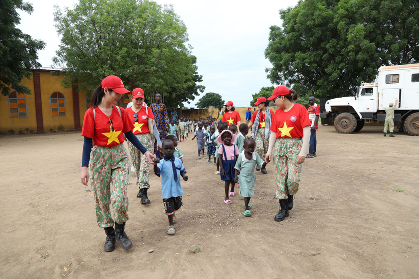 Nữ chiến sĩ Công binh Việt Nam dẫn các em nhỏ tại Abyei đi xem phim hoạt hình.