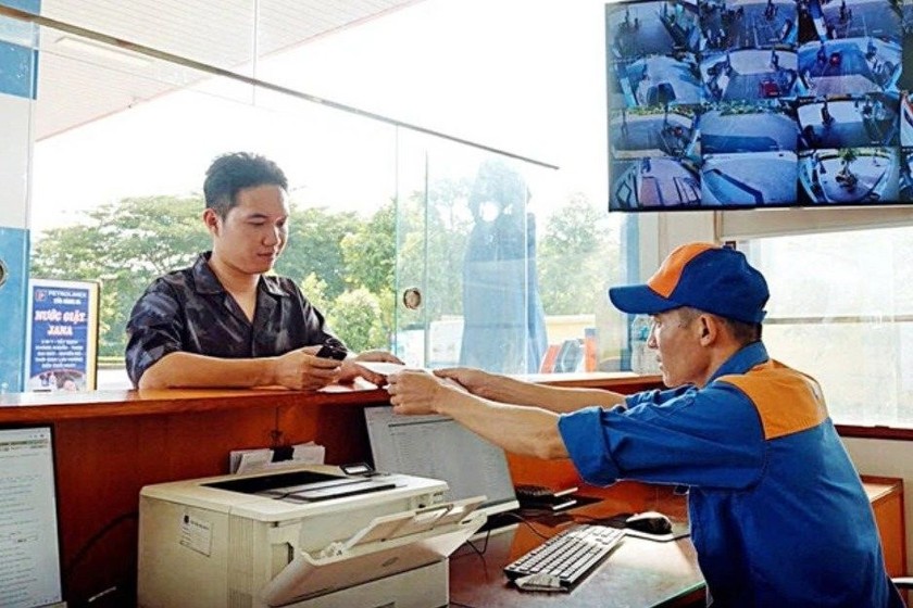 Nhân viên cửa hàng Petrolimex xuất hóa đơn giấy từ hệ thống hóa đơn điện tử cho khách hàng. (Ảnh: N.K.H)