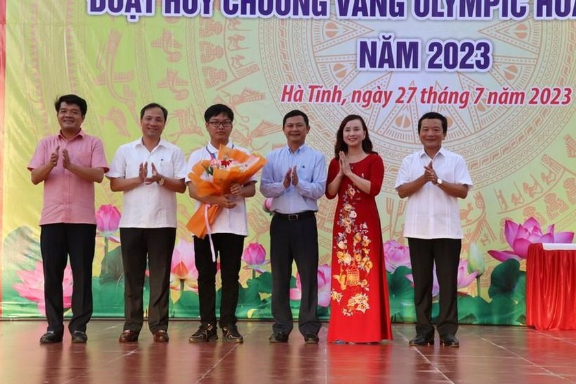 Lãnh đạo tỉnh Hà Tĩnh, Sở GDĐT Hà Tĩnh tặng hoa chúc mừng em Đinh Cao Sơn. Ảnh: PV