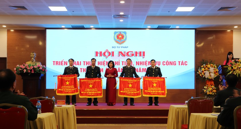 Thứ trưởng Bộ Tư pháp Đặng Hoàng Oanh trao Cờ Chính phủ cho Cục THADS Khánh Hoà (ngoài cùng bên phải), đơn vị xuất sắc trong phong trào thi đua 2018.