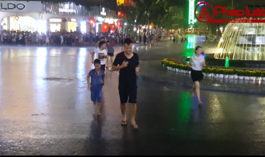 Người dân chạy tan tác dưới cơn mưa lớn trên phố đi bộ ngày đầu hoạt động