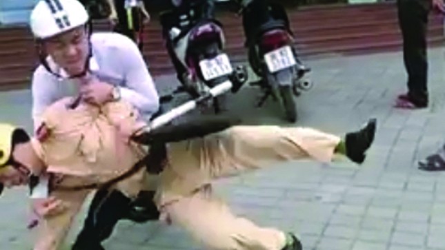 Cảnh sát giao thông Thanh Hóa bị kẹp cổ, vật ngã giữa đường (Ảnh chụp từ clip)
