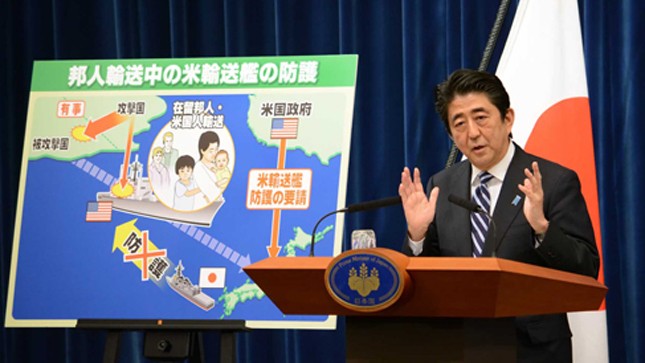 Ông Abe phát biểu trước bức tranh minh họa cảnh tàu Mỹ chở công dân Nhật bị tấn công - Ảnh: AFP