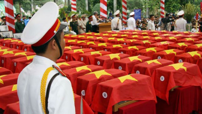 Hơn 100 hài cốt liệt sĩ được phủ kín cờ tổ quốc trước lễ truy điệu và an táng. Ảnh: Hoàng Trường
