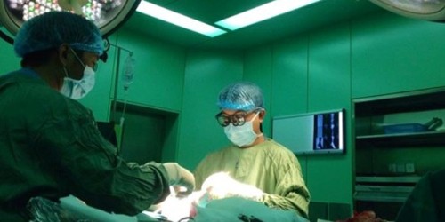 Các bác sĩ đang phẫu thuật cho nối mạch máu chân cho cụ ông.