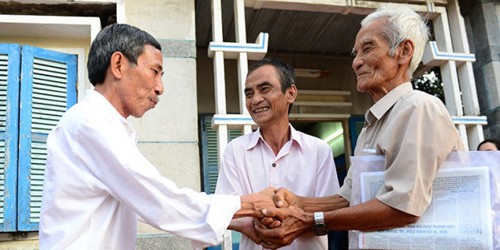 Cha con ông Huỳnh Văn Truyện và Huỳnh Văn Nén bắt tay ân nhân của mình là thầy giáo Nguyễn Thận (bìa trái) - Ảnh: Quang Định (TTO)