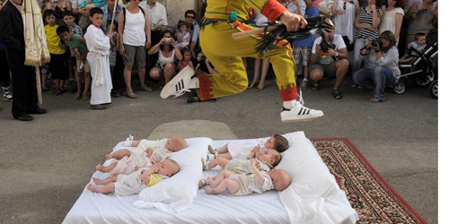 Một người đàn ông đại diện cho ma quỷ thực hiện nghi thức nhảy qua đầu trẻ em. 