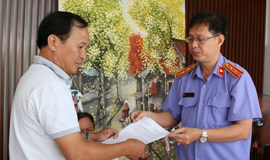 Đại diện Viện KSND H.Bình Chánh (TP.HCM) trao các quyết định nhằm phục hồi danh dự cho ông Nguyễn Văn Tấn, chủ quán cà phê Xin Chào - Ảnh: Công Nguyên - Thanh Niên