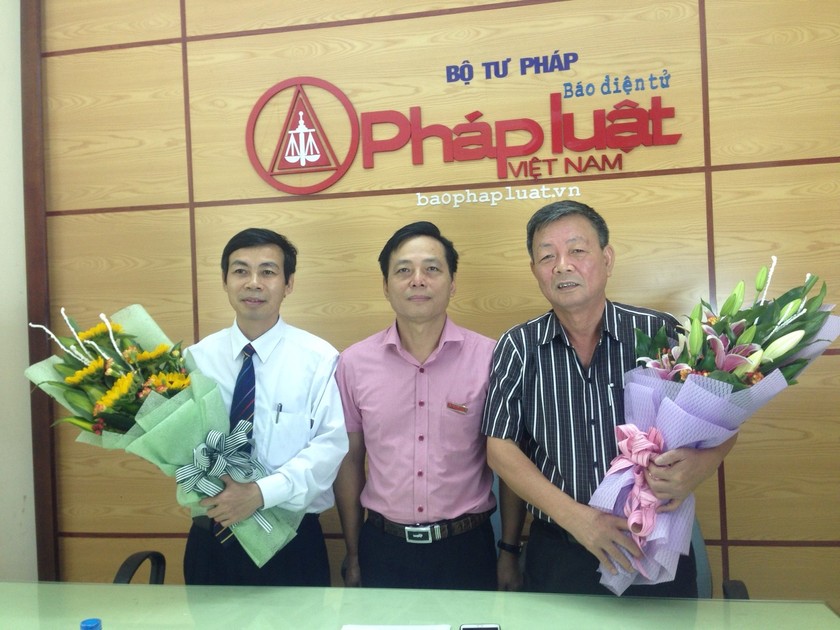 Phó TBT Báo Pháp luật Việt Nam Vũ Hoàng Diệp (giữa) tặng hoa cảm ơn Luật sư Vũ Văn Lợi và ông Nguyễn Văn Hòa