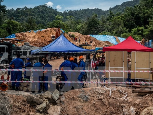 Nhân viên cứu hộ tìm kiếm các nạn nhân sau vụ lở đất. (Nguồn: AFP/TTXVN)