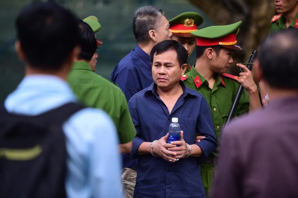 Bị cáo Thanh Minh Hùng (giữa) được dẫn giải đến tòa - ảnh Tuổi trẻ