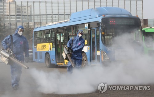 Các quan chức y tế khử trùng một bến xe buýt công cộng ở phía đông Seoul vào ngày 20 tháng 2 năm 2020. (Yonhap)