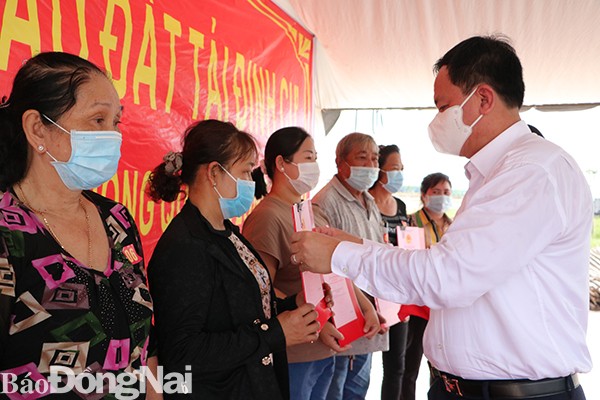 Phó chủ tịch UBND tỉnh Võ Tấn Đức trao quyết định bàn giao đất và Giấy chứng nhận quyền sử dụng đất cho các hộ dân- Ảnh Báo  Đồng Nai.