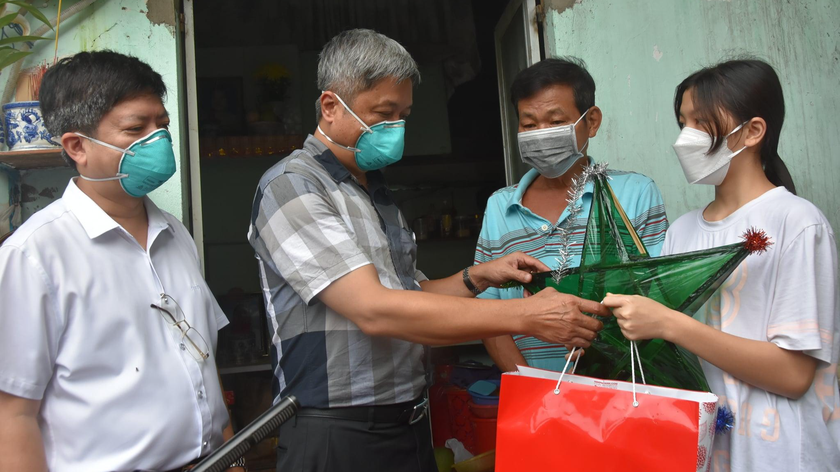 Thứ trưởng Y tế Nguyễn Trường Sơn (thứ 2 từ trái qua) thăm và tặng quà một em nhỏ có người thân mất do COVID-19 tại TP HCM, ngày 20/9/2021. 