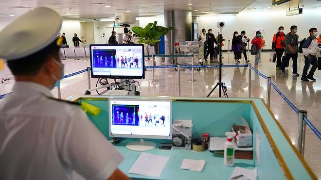 Đo thân nhiệt cho người nhập cảnh tại sân bay Tân Sơn Nhất. 