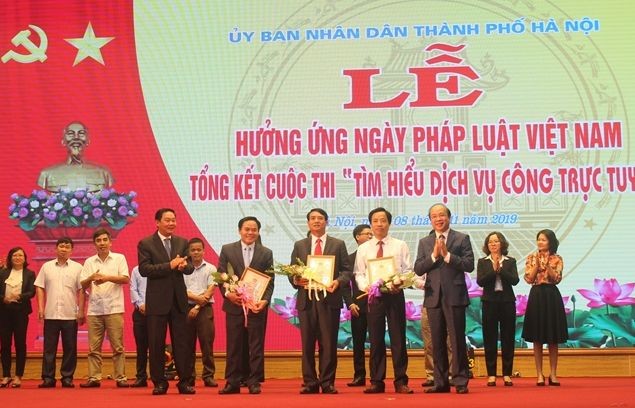 Thứ trưởng Phan Chí Hiếu và Phó Chủ tịch thường trực UBND TP Hà Nội Lê Hồng Sơn trao giải cho các cá nhân đạt giải cuộc thi tìm hiểu pháp luật tại Lễ hưởng ứng Ngày Pháp luật năm 2019. 